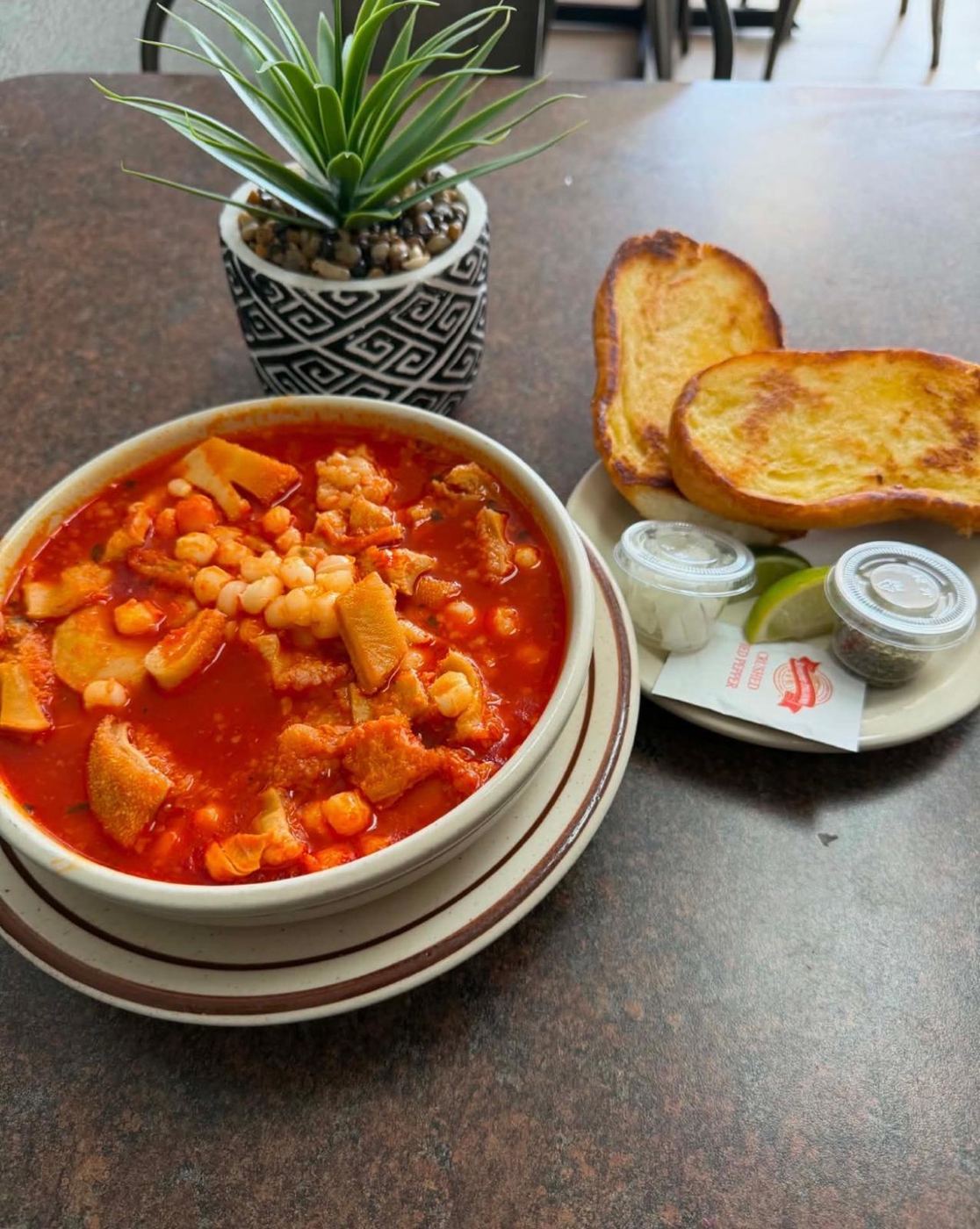 Bowl of menudo with hominy and grilled bread at Maribu's Mexican Restaurant in El Paso, TX