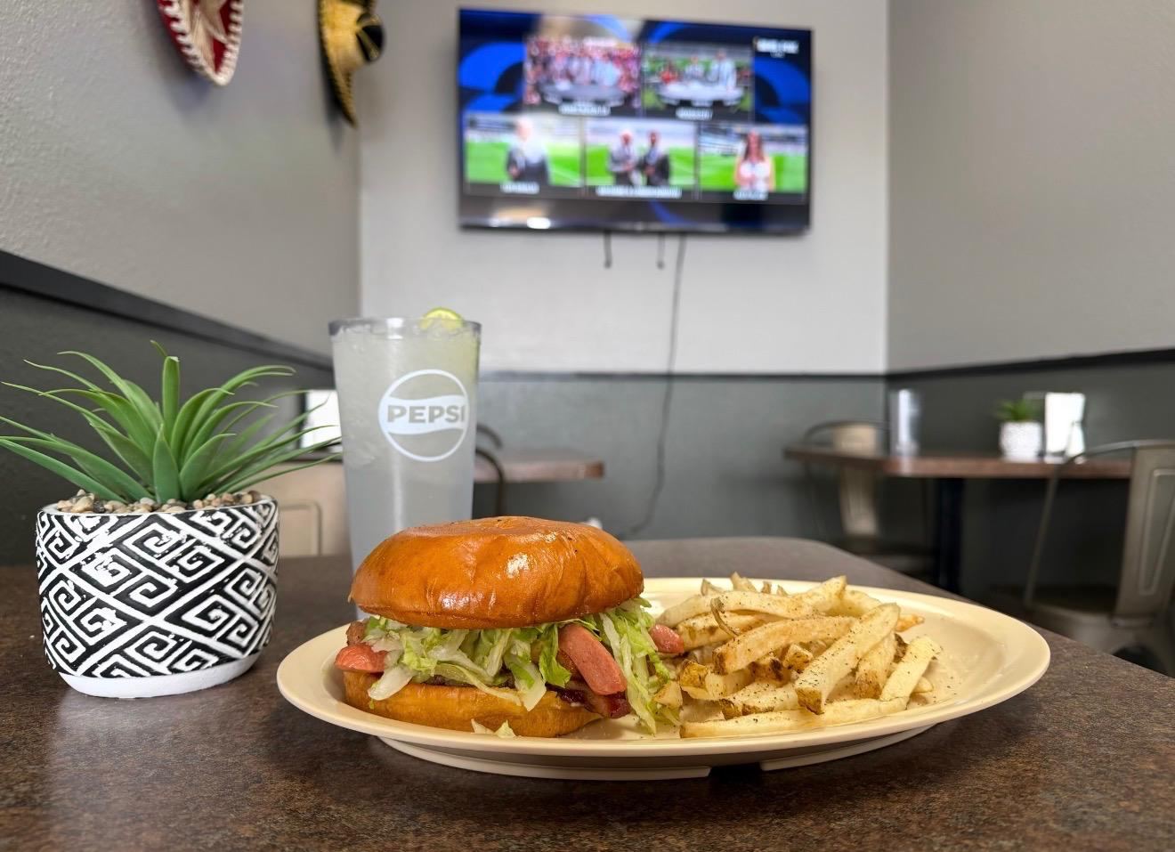 Hamburger and seasoned fries with a fútbol match on the TV at Maribu's Mexican Restaurant on Edgemere Blvd, El Paso