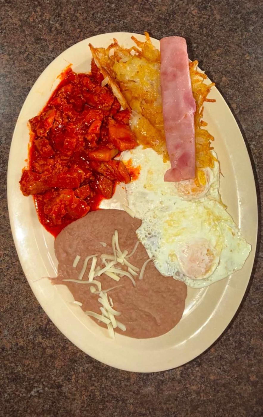 Chile colorado breakfast plate with eggs, ham, hash browns and refried beans at Maribu's in El Paso, Texas